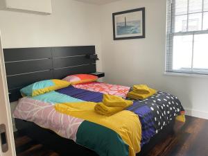 sypialnia z 2 łóżkami i kolorową pościelą w obiekcie HipNautic, Mevagissey, Sleeps 6 w mieście Mevagissey