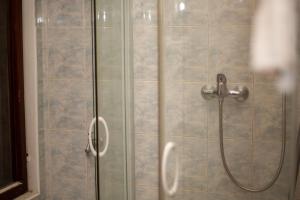 a shower stall with a glass door with a shower at Seaview apartment Mimice in Mimice