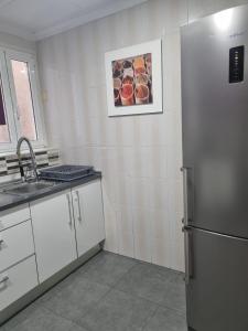 cocina con nevera y fregadero en Habitación2 piso lavanda, en Villena