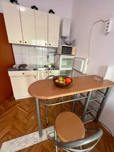 a small kitchen with a table with a bowl of fruit on it at Seaview apartment Mimice in Mimice