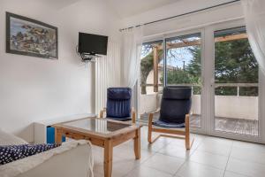 ein Wohnzimmer mit 2 Stühlen und einem Tisch in der Unterkunft Maison a trois cent metres de la plage in Saint-Nazaire