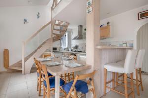 a kitchen with a table and chairs and a staircase at Maison a trois cent metres de la plage in Saint-Nazaire