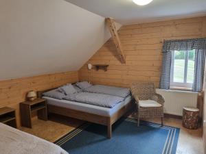 a bedroom with a bed and a chair at Penzion Bouda Na stráni in Dolní Malá Úpa