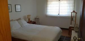 a bedroom with a white bed and a window at Sines Ocean View Apartment in Sines