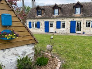 una casa con persianas azules y un pájaro en un patio en Maison de Campagne Le Pâtis aux Chevaux proche circuit 24H et Le Mans, en Challes