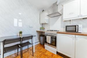 a kitchen with white cabinets and a counter top at Holloway Road Double rooms - 5 in London