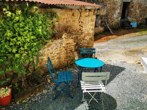 uma mesa e cadeiras sentadas em frente a um edifício em Maisonnette em Bourneau