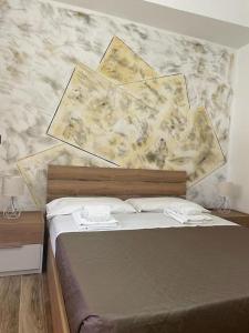 uma cama num quarto com uma parede de mármore em B&BUrszula Gizzeria Lido em SantʼEufemia Lamezia