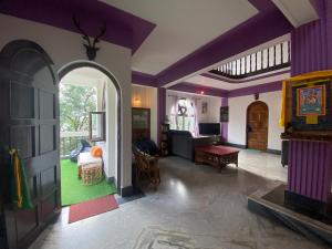 a room with purple walls and a living room at Tashila Hostel in Gangtok