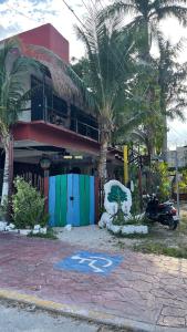 una motocicleta estacionada frente a un edificio con palmeras en Near Lake Hostal, en Bacalar