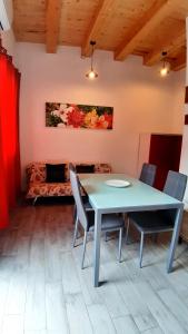 a table and chairs in a room with a couch at Casanuova Flat, City Center in Olbia