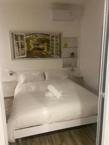 ein weißes Bett mit zwei Kissen darauf im Schlafzimmer in der Unterkunft Exclusive Mood Apartment in Rom