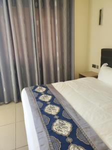 a bedroom with a bed and a curtain at Lagoonbeachhotel in Keta