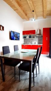 a kitchen with red cabinets and a table and chairs at Casanuova Flat, City Center in Olbia +13 photos