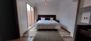 a bedroom with a bed and a large window at villa Marrakech piscine privée in Marrakesh