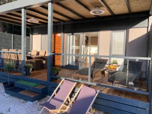 a deck with two purple chairs and a table at Mobile home Dream , Camp Porton Biondi- Rovinj in Rovinj