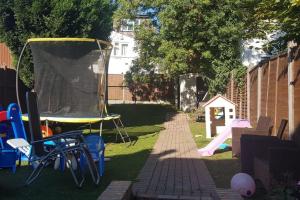 a backyard with a trampoline and a play set at Hendon home in Hendon