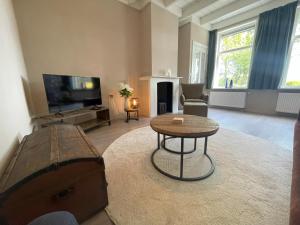 a living room with a tv and a coffee table at Appartement Elperhof 16A in Schoonloo
