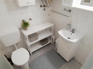 een witte badkamer met een toilet en een wastafel bij Apartment or room at Irena's in Piran +13 foto's