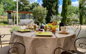 a table with food and drinks on top of it at Domaine Au Coeur des Alpilles in Maussane-les-Alpilles