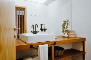 baño con lavabo blanco en una encimera de madera en Casa do Santo - Wine & Tourism, en Provesende