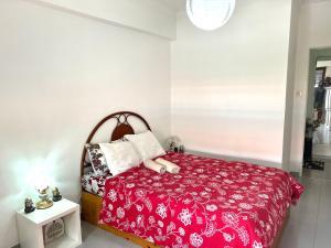 um quarto com uma cama com um edredão vermelho em Charming House 2 na Amadora