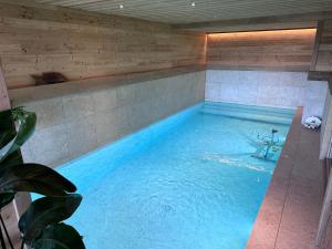 una piscina en una habitación con una pared de madera en Chalet La Petite Ourse en Hohrod