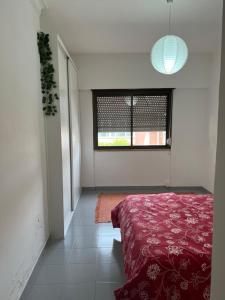 a bedroom with a red bed and a window at Charming House 2 in Amadora