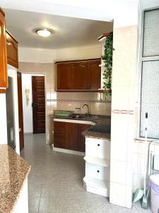 uma cozinha com armários de madeira e um lavatório em Charming House 2 na Amadora