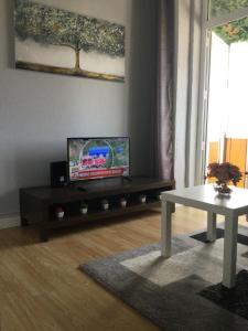 Una sala de estar con un televisor y una mesa. en Vicky Porto, en Oporto