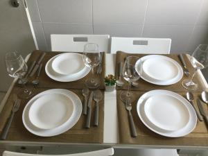 una mesa con platos blancos y copas de vino. en Vicky Porto, en Oporto 9 fotos más