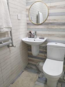 ein Badezimmer mit einem WC, einem Waschbecken und einem Spiegel in der Unterkunft Novxani jorat beach area in Sumqayıt