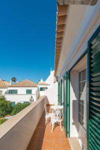een witte stoel op het balkon van een huis bij Casa Oceanus - 2BDR House w Pool & Balcony in Cabanas de Tavira