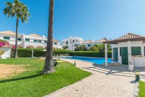 een villa met een zwembad en een palmboom bij Casa Oceanus - 2BDR House w Pool & Balcony in Cabanas de Tavira
