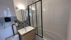 une salle de bain avec une douche, un lavabo et un miroir dans l'établissement Appartement 2 pièces en rez-de-chaussée dans résidence avec accès direct à la plage, à Cabourg 10 autres photos