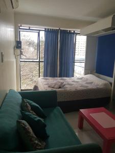 a bedroom with a bed and a couch and a window at Luminoso monoambiente con cochera propia dentro del edificio in La Plata