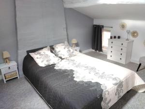 Gîte des Bujours في Saint-Bris-des-Bois: غرفة نوم بسرير كبير وخزانة