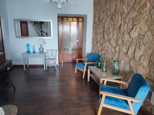 un soggiorno con sedie blu e un muro in pietra di Son MASSANET, con piscina y fantásticas vistas a Campanet