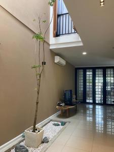 una sala de estar con un árbol en el medio. en Timurahaus en Kajang