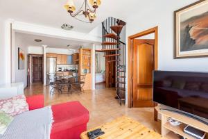 a living room with a red couch and a table at Buddha penthouse solarium+pool in Gáldar