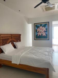 een slaapkamer met een groot bed en een plafondventilator bij Timurahaus in Kajang