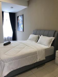 a bedroom with a large white bed with a window at Timurahaus in Kajang