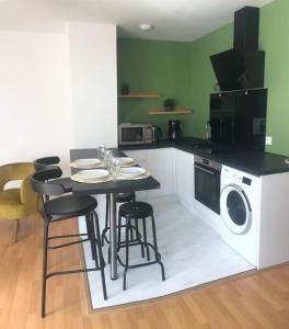 a kitchen with a table and chairs and a washing machine at le Garden de plein pied in Mainvilliers