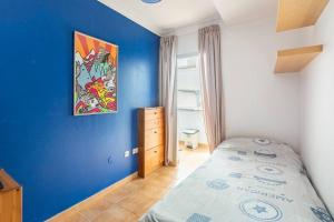 a bedroom with a blue wall and a bed at Buddha penthouse solarium+pool in Gáldar +42 photos
