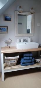 bagno con lavandino, specchio e asciugamani di Les Balcons du Canet a Gonneville-sur-Honfleur