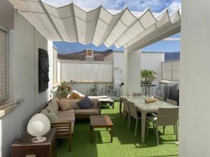 a living room with a couch and a table at Buddha penthouse solarium+pool in Gáldar