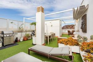 a patio with a table and a grill on a balcony at Buddha penthouse solarium+pool in Gáldar