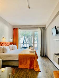 sypialnia z dużym łóżkiem i pomarańczowym kocem w obiekcie Villa ReTa Hotel & SPA w mieście Grigoleti