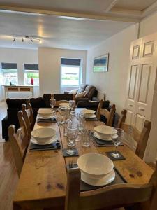 - une table à manger avec des assiettes et des verres dans l'établissement Netherby Grange Garden Apartment with Sea Views, à Llandrillo-yn-Rhôs