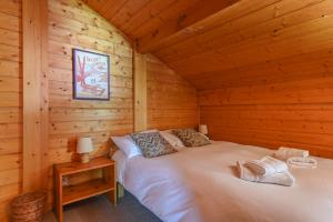 ein Schlafzimmer mit einem Bett in einem Blockhaus in der Unterkunft Chalet de Vantaa in Les Gets